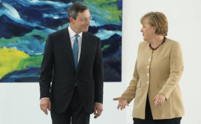 Na zona euro, este aparente paradoxo da política monetária é a expressão de problemas mais profundos - Foto Mario Draghi e Angela Merkel