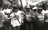 Manifestação de pessoas HIV positivas na Cidade do Cabo em 2002, no âmbito da Treatment Action Campaign que defrontou Thabo Mbeki o presidente negacionista da SIDA. Foto de Louis Reynolds/Flickr.
