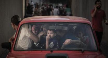 Família palestiniana foge depois de mais um bombardeamento em Gaza. Foto de APA Images