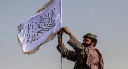 Combatente talibã ergue a sua bandeira num veículo em Kandahar. Foto de STRINGER/EPA/Lusa.