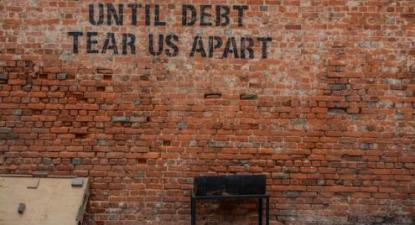 Parede com a frase: "Until debt tear us apart"