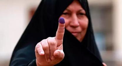 Uma mulher iraquiana mostra o dedo “pintado” como sinal de que votou nas eleições de 12 de Maio de 2018. Foto: fornecida pelo governo iraquiano e publicada em https://diyaruna.com
