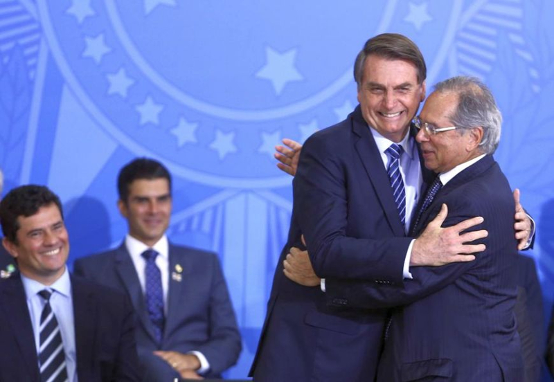 Bolsonaro abraça Paulo Guedes em evento no Palácio sob o olhar e o sorriso de Sérgio Moro, em 2019. Crédito: Valter Campanato/Agência Brasil 