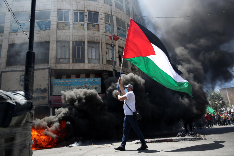 “o adiamento das eleições e a escalada de violência de Israel contra Palestinianos, seja dentro da Faixa de Gaza, na Cisjordânia ou em Jerusalém Oriental, leva a que a sociedade civil Palestiniana se encontre uma vez mais, impossibilitada de fazer-se ouvir” - Manifestante palestiniano em Hebron. Foto de Abed Al Hashlamoun/EPA/Lusa.