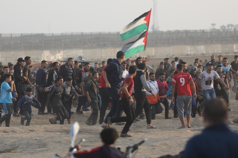 “Quando os Palestinianos procuraram demonstrar-se pacificamente e deram início à Marcha de Retorno foram recebidos com violência que levou à morte de 214 pessoas” - Palestinianos reúnem-se na cerca de separação para a Grande Marcha do Retorno, 8 de novembro de 2019 – foto Mohammed Asad/Monitor do Oriente