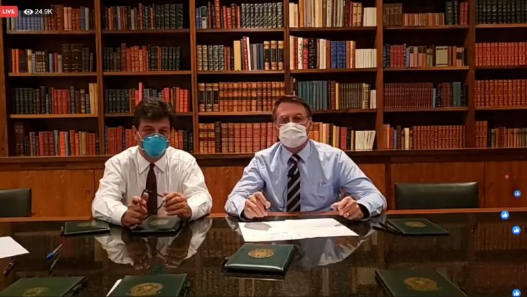 Bolsonaro, de máscara, ao lado do ministro da Saúde, pediu o cancelamento das manifestações pelo perigo de contágio massivo. A preocupação durou menos de 48 horas